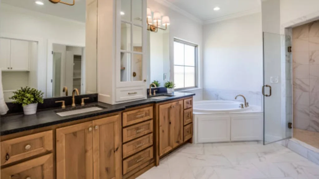 Rustic-modern bathroom with wood cabinetry, black countertops, tub, and glass shower. -bathroom remodeler